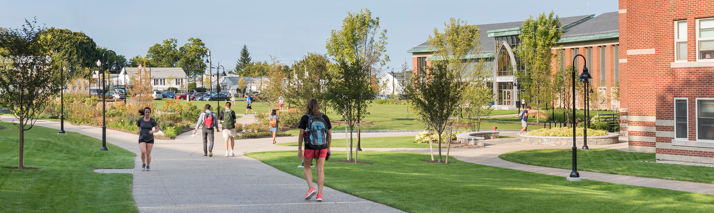 students walking and running in front of Ryan Center and McCarthy Hall